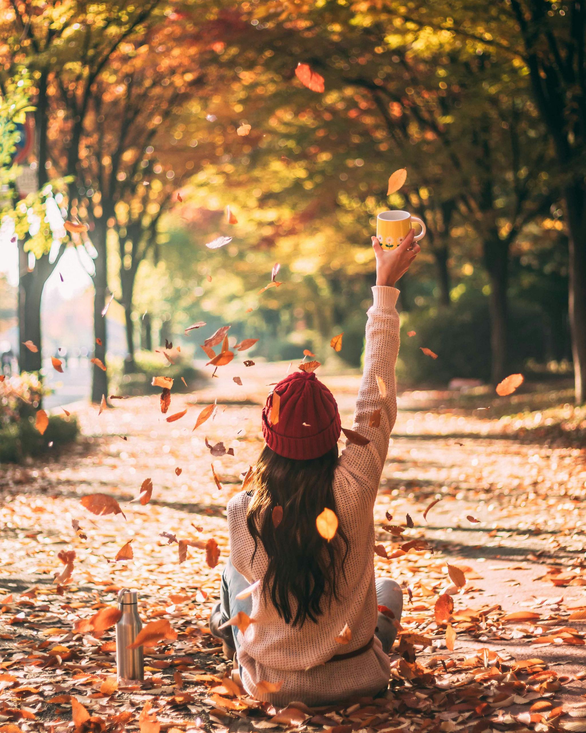 Woman Sitting on Dry Leaves on Ground