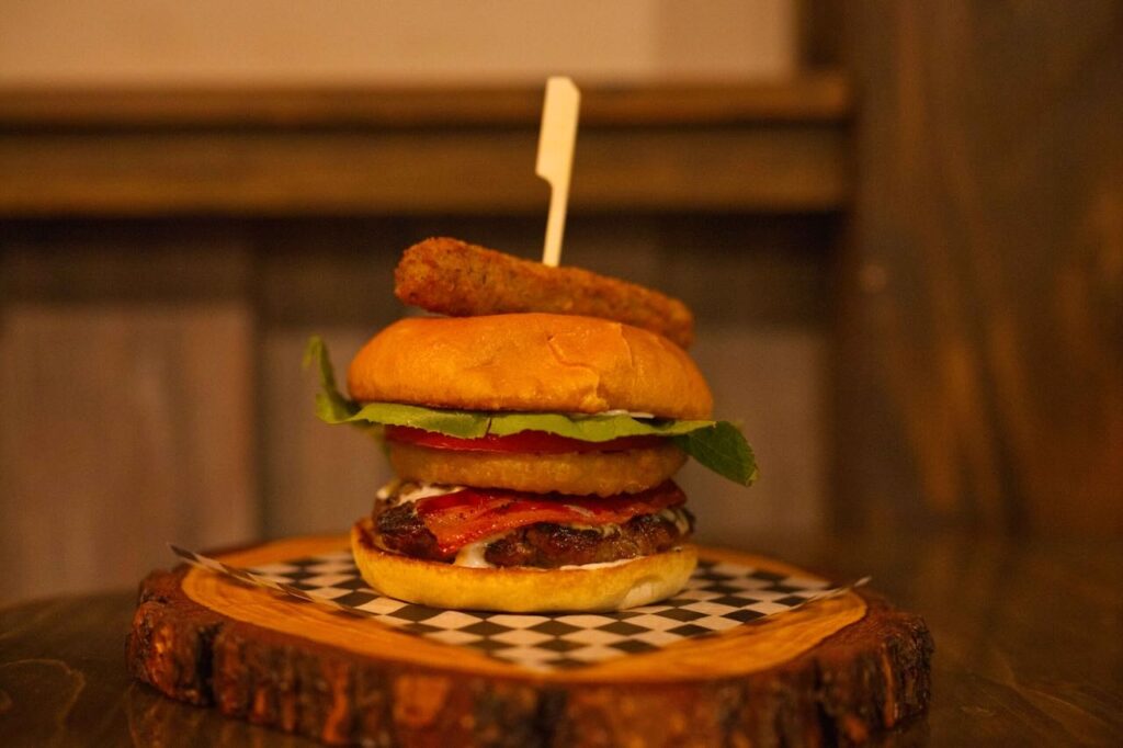 burger with blue cheese and onion ring at Junction Eatery Salmo