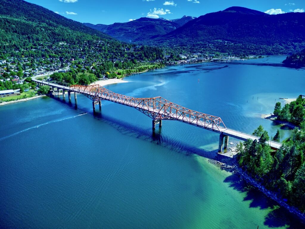 Nelson's iconic orange bridge with kootenay lake in summer