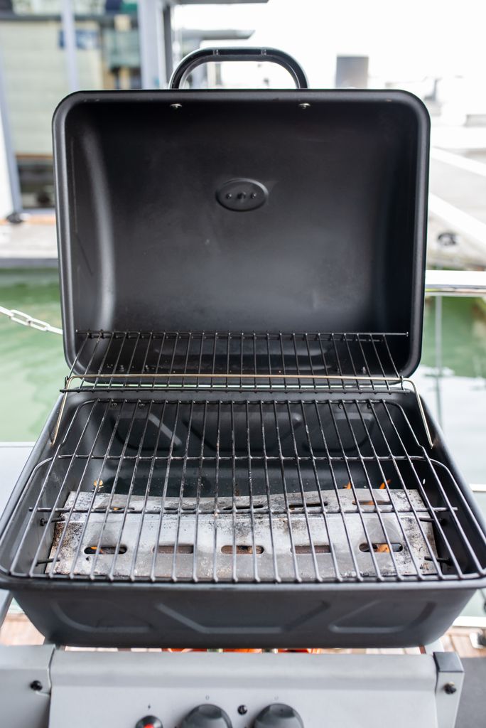 Empty black grill ready for barbecue in a stylish outdoor area.
